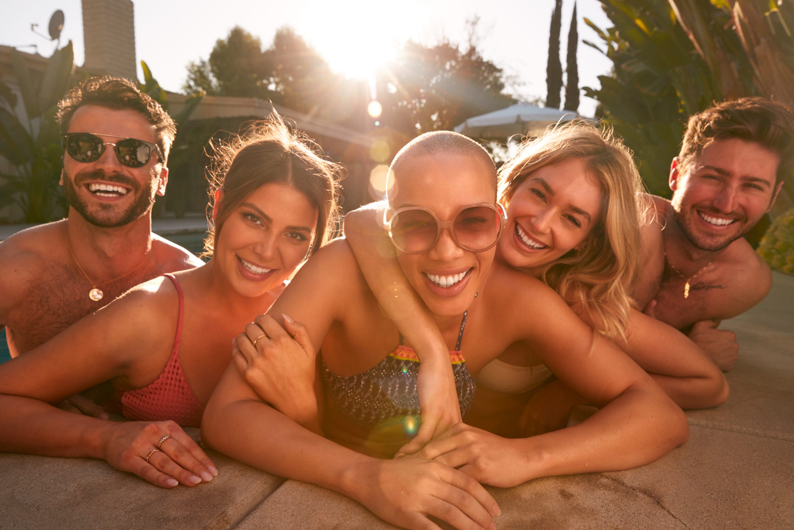 Portrait Of Group Of Friends Outdoors Relaxing In Swimming Pool And Enjoying Summer Pool Party