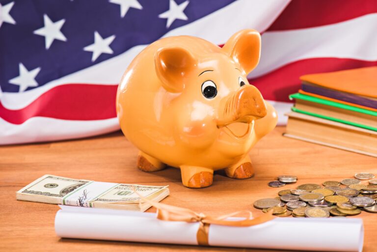 diploma and piggy bank with coins and dollars usa flag behind, education concept